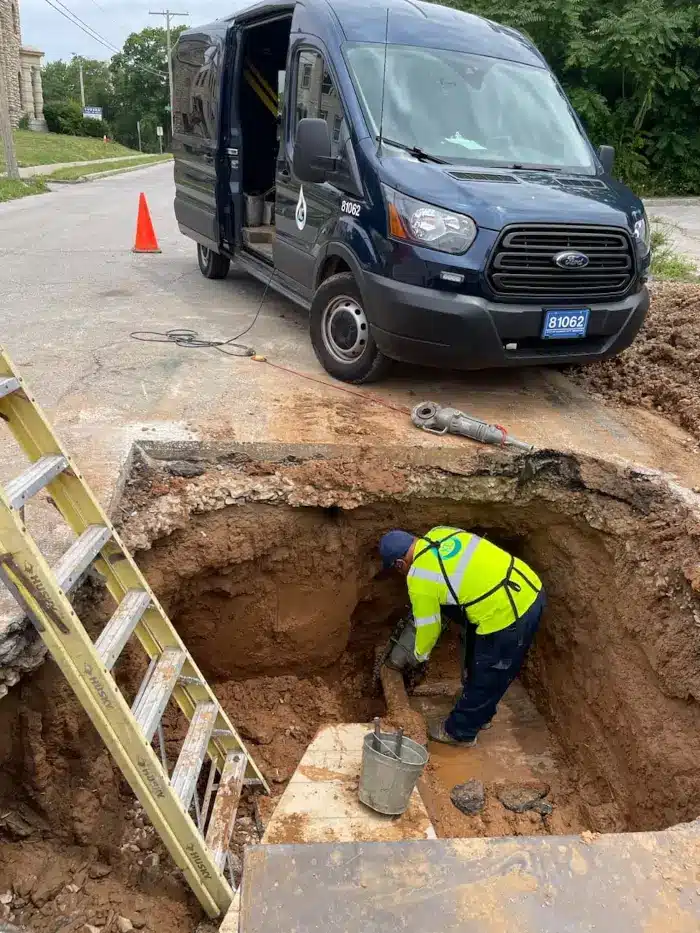 Signs of a Water Line Leak in Kansas City (and What to Do Next) 1 John the Plumber technician working down in a street excavation to repair a water line leak at the meter and curb stop in Kansas City